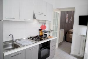 a kitchen with a sink and a stove top oven at Casa Vacanze La Coccinella in Trapani