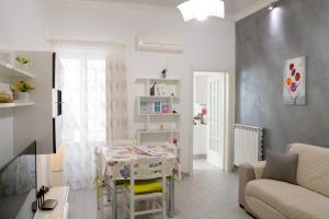 een witte woonkamer met een tafel en een bank bij Casa Vacanze La Coccinella in Trapani