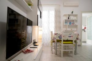 een woonkamer met een grote televisie en een tafel en stoelen bij Casa Vacanze La Coccinella in Trapani