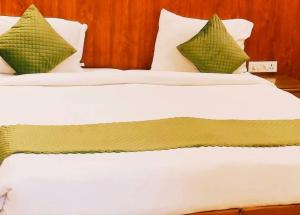 2 łóżka z białymi i zielonymi poduszkami w pokoju w obiekcie Hotel Aroma Residency Premium 47 Corporate,Family,Friendly,Couple Friendly Near - Unitech Cyber Park & IKEA w mieście Gurgaon