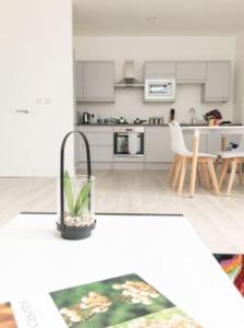 a kitchen with white cabinets and a table with a plant at Zenith at Fleet Heights Apartment Three in Fleet