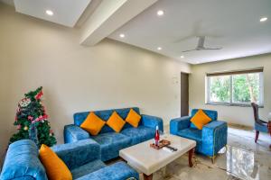 un soggiorno con un divano blu e un albero di Natale di Premium 2BHK Apartment with pool at Candolim Beach a Candolim