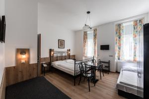 Schlafzimmer mit einem Bett, einem Tisch und Stühlen in der Unterkunft Hotel Terminus in Wien