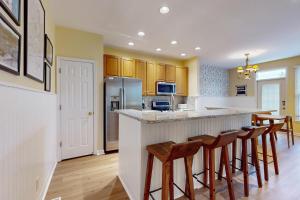 una cucina con bancone e sgabelli di Bear Trap Dunes - 17 Village Green a Ocean View