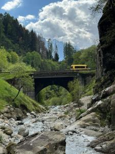 un autobús amarillo en un puente sobre un río en B&B il riccio, en Paspardo