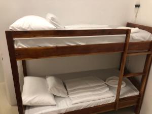 a bunk bed with white sheets and pillows on it at Cuestas Beach Resort and Restaurant in Badian