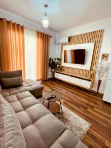 a living room with a couch and a television at Laurent's Durres sea apartment in Durrës