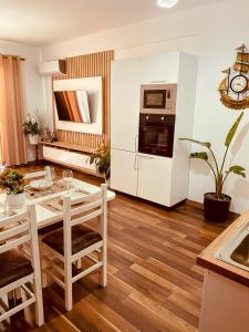 a kitchen with a table with chairs and a microwave at Laurent's Durres sea apartment in Durrës