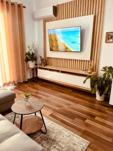 a living room with a flat screen tv on a wall at Laurent's Durres sea apartment in Durrës