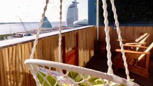 einen Balkon mit 2 Stühlen und einer Schaukel in der Unterkunft COAST HOUSE Moana in Bremerhaven