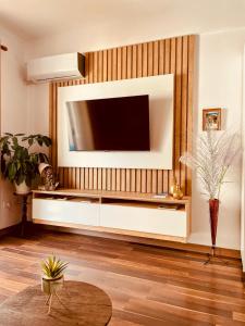 a living room with a television on a wall at Laurent's Durres sea apartment in Durrës