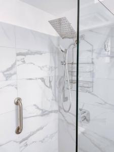 a white bathroom with a shower with a glass door at LaBellevue Benjamin's Holiday Rental Home﻿ in Crosbies