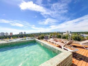 a swimming pool with chaise lounge chairs on a roof at Michelangelo 806 in Punta del Este