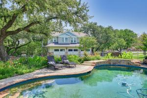 una piscina con 2 sillas frente a una casa en Charming Fort Worth Apartment - 8 Mi to Downtown!, en Fort Worth