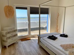 ein Schlafzimmer mit einem Bett und einem großen Fenster in der Unterkunft COAST HOUSE Sky Suite in Bremerhaven