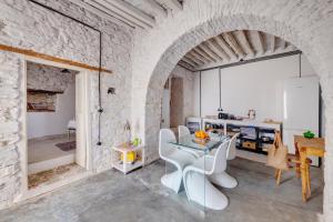 a kitchen with a glass table and white chairs at Syros Art House in Ano Syros