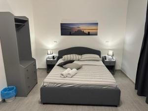 Affittacamere Gess في مونتالتو أوفوجو: غرفة نوم مع سرير مع مواقف ليلتين ومصباحين
