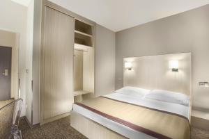 a bedroom with a large bed and a closet at Hotel Hartig in Prague