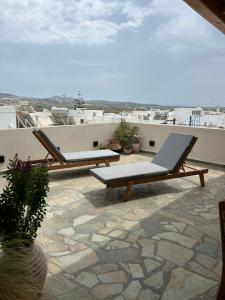 a patio with two lounge chairs on a roof at Naxian Icon Luxury Residence in Naxos Chora