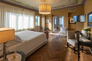 a bedroom with a large bed and a living room at Villa Pattono Relais in Costigliole dʼAsti