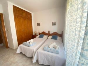 1 dormitorio con 2 camas y toallas. en Apartamentos Copacabana Playa, en La Manga del Mar Menor