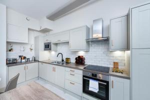 eine weiße Küche mit weißen Schränken und einer Spüle in der Unterkunft Byard Lane - Nottingham Luxury 2BR Apartment in Nottingham