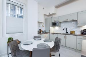 eine weiße Küche mit einem Tisch und Stühlen in der Unterkunft Byard Lane - Nottingham Luxury 2BR Apartment in Nottingham