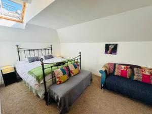a bedroom with a bed and a couch at Stylish modern Mews house in central St Leonards in Hastings