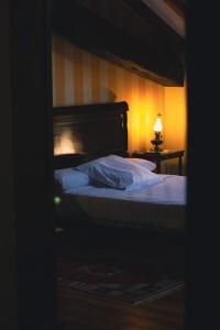 a bedroom with a bed and a lamp on a table at Hotel Palacio La Casona de Cerrazo in Cerrazo