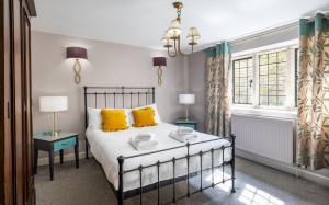 een slaapkamer met een bed met gele kussens bij The Old School Rooms Beautiful Georgian apartment, sleeps 12 with Wifi and Parking, near Bath in Box