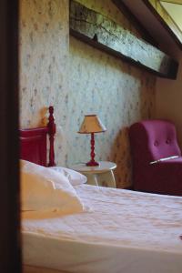 a bedroom with a bed and a chair and a lamp at Hotel Palacio La Casona de Cerrazo in Cerrazo +50 photos