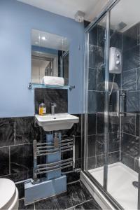 a bathroom with a sink and a shower at The Old School Rooms Beautiful Georgian apartment, sleeps 12 with Wifi and Parking, near Bath in Box