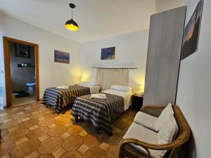 ein Hotelzimmer mit 2 Betten und einem Stuhl in der Unterkunft Antonhouse Alghero in Alghero