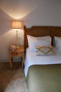 1 dormitorio con 1 cama y 1 mesa con lámpara en Villa Madra, en Bonifacio
