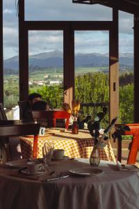 Hotel Palacio La Casona de Cerrazo في Cerrazo: طاولة مطلة على الجبال من خلال النافذة