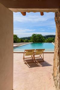 ein Paar Stühle auf einer Terrasse in der Nähe eines Pools in der Unterkunft Agroturisme Subies in Selva