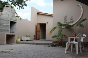 a patio with two chairs and a building at Wild Eden Self-Catering Accommodation in Swakopmund