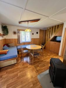 a room with a bed and a table and a bed and a dining room at Chaty Vysočina in Polesí