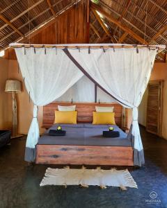 Miavaka Lodge في Ambatobe: غرفة نوم بسرير مع ناموسية