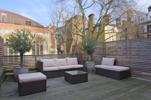 a patio with two couches and a bench and trees at Clerkenwell Premium Deluxe in London