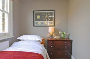 a bedroom with a bed and a dresser with a lamp at Clerkenwell Premium Deluxe in London