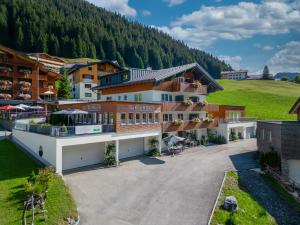 a view of a hotel with a mountain in the background at Hotel Garni Krumbach in Damuls