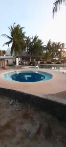 duży basen z palmami i budynek w obiekcie La Maison transient house w mieście Calapan