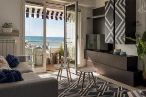 a living room with a couch and a view of the ocean at fronte mare spiaggia - marine 59 in Diano Marina