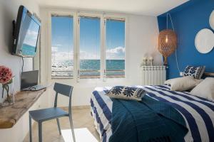 a bedroom with a bed and a desk and a television at fronte mare spiaggia - marine 59 in Diano Marina