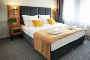 una camera da letto con un grande letto con asciugamani di FACTORY RESORT wellness & spa a Kołobrzeg