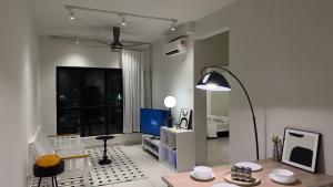 a living room with a table and a lamp at MRT asthetic condo in Kuala Lumpur