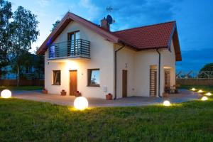 a house with lights in the yard at Piaskowe Domki in Grzybowo