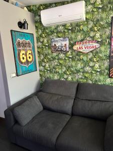 un salon avec un canapé en face d'un mur dans l'établissement Route 66 Apartment, à Gravina di Catania