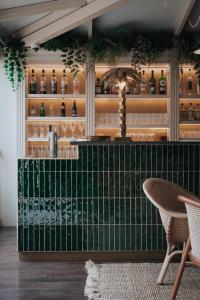 a bar with a table and chairs in a room at Hôtel Henry II Beaune Centre in Beaune